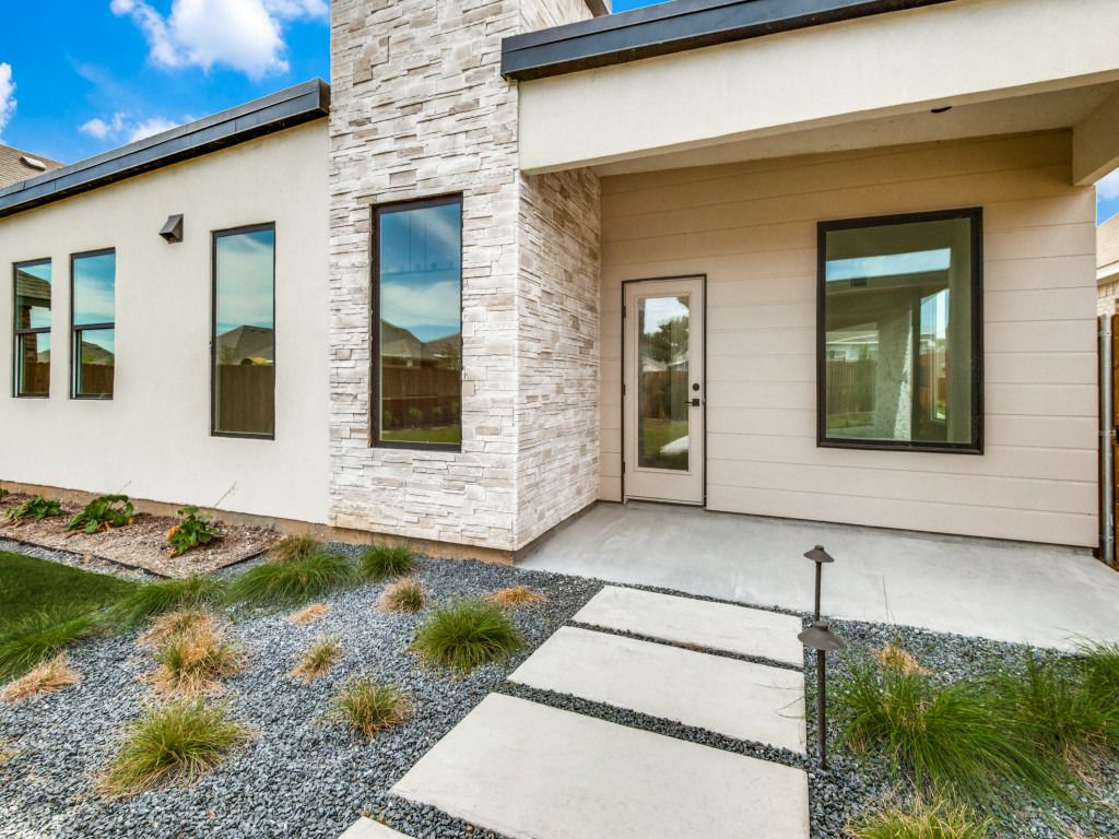 Front entry courtyard with stone and stucco walls and a gravel garden